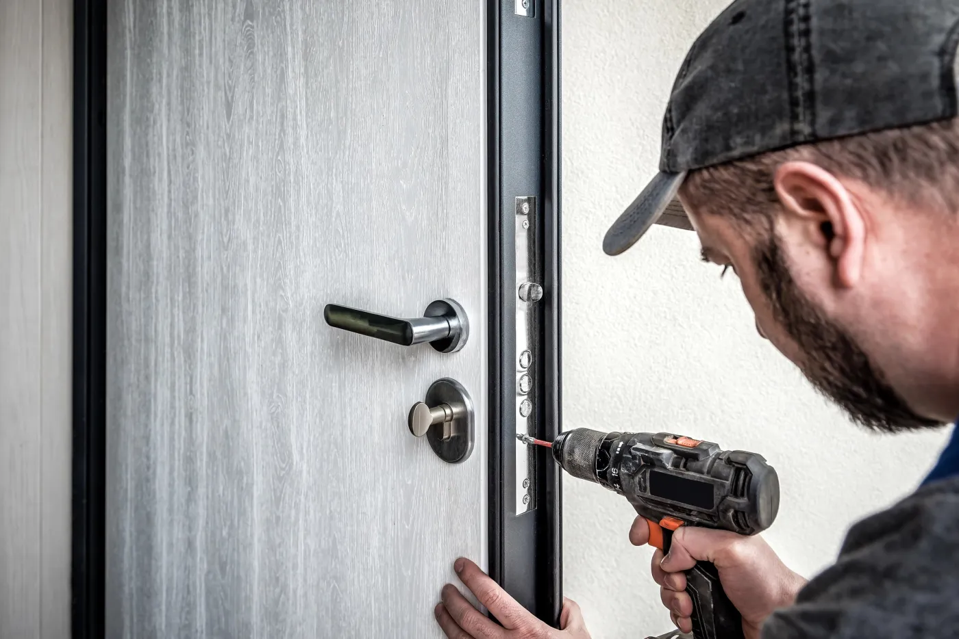 Serrurier muriautin posant un renfort acier sur une porte d'entrée aux Mureaux (78130)